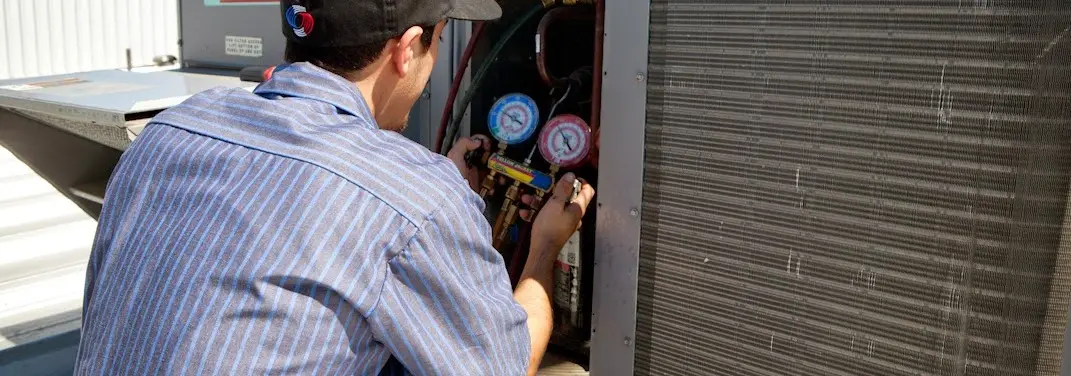 HVAC technician servicing a condenser unit in Harker Heights