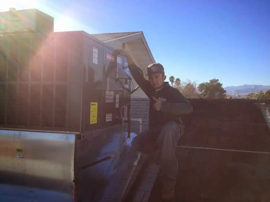 HVAC technician performing Heat Pump Repair on a rooftop unit in Harker Heights